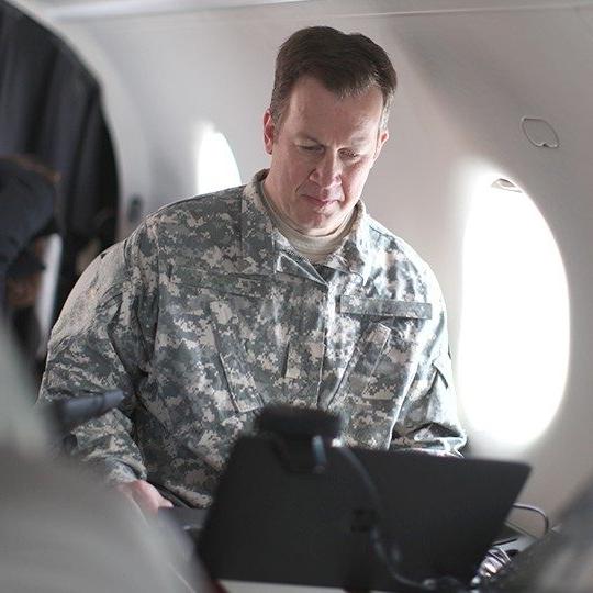一名战士在乘坐配备双频天线的政府飞机时连接着他的笔记本电脑
