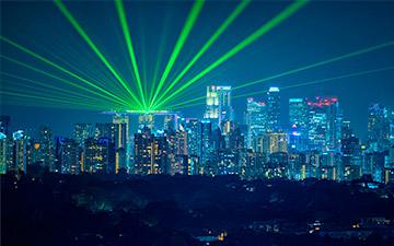 城市天际线的图像，明亮的绿色灯光照亮夜空